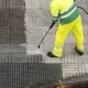 worker cleaning street sidewalk high pressure water jet worker cleaning street sidewalk high pressure water jet