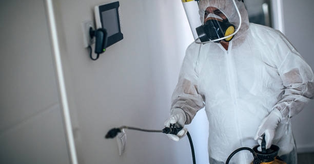 One man, man in protective suit disinfecting residential building alone
