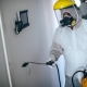 One man, man in protective suit disinfecting residential building alone